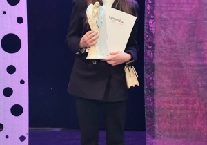 Ula z dyplomem i statuetką w kształcie Anioła.