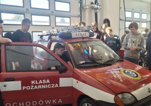 Uczniowie podczas zajęć praktycznych w warsztacie samochodowym