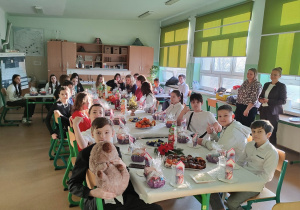 Wigilia w klasie 6a. Uczniowie siedzą za stołem wigilijnym.