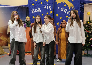 Dziewcząta klasy 6 śpiewają pastorałkę podczas jasełek szkolnych.