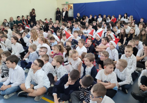 Duża grupa uczniów zapatrzona w spektakl jasełek.