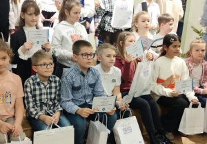Duża grupa wyróżnionych uczniów z nagrodami.