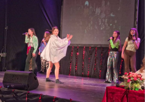 Grupa dziewcząt na scenie podczas swojego występu.