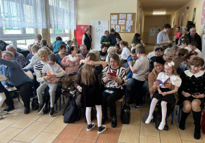 Wnuczęta wręczają własnoręcznie wykonane laurki swoim babciom i dziadkom.