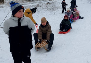 Uczniowie podczas szlonych zjadów na sankach.