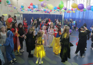 Duża grup poprzebieranych za różne postaci uczniów podczas balu