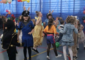 Duża grup poprzebieranych za różne postaci uczniów podczas balu