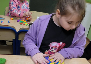 Kreatywne budowanie. Dziewczynka buduje psa.