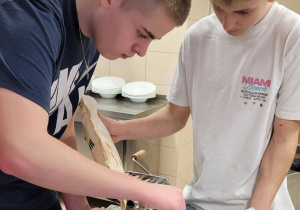 Dwóch uczniów podczas warsztatów kulinarnych.