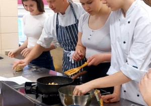 Uczniowie wraz z nauczycielem technologii żywienia przygotowuja makaron.