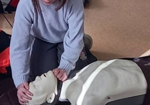 Uczennica podczas udzielania pierwszej pomocy.