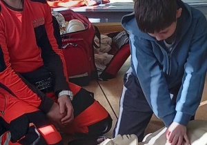 Uczeń z medykiem podczas reanimacji pacjenta.