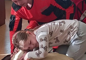 Uczennica sprawdza czy pacjent oddycha.