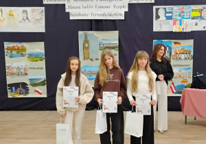 Przy nagrodzone dziewczęta na tle prac plastycznych