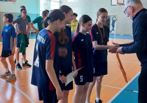 odbierają dyplom i medle z rąk przedstwiciela PSZS