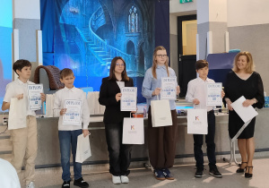 Marianna wraz innymi nagrodzonymi uczniami, stoi z ngrodą i dyplomem.