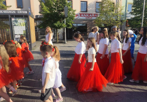 Grupa uczennic w biało czerwonych strojach podczas parady