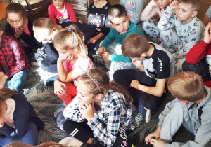 Dzieci słuchają historii czytanej przez starszą koleżankę