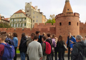 Grupa uczniów na tle barbakanu.