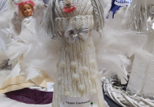 Aniołek w sukience wykonanej z rękawa wełnianego swetra przyozdobionej perełkami.