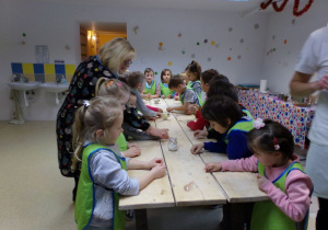 Dzieci przy stole przygotowują ciastaka.