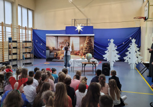 Sala gimnastyczna. Na pierwszym planie widownia. Za widownią scena z jasełkami.