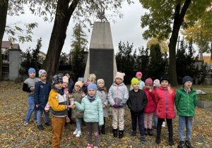 Dzieci na cmentarzu zapalają znicze na grobach żołnierzy