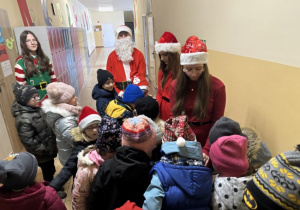 Dzieci dostają słodycze od przedstawicieli Samorządu Uczniowskiego