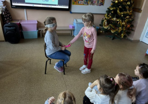 Dzieci uczestniczą w zabawie dydaktycznej: Kalambury (poznawanie przez zmysł dotyku)