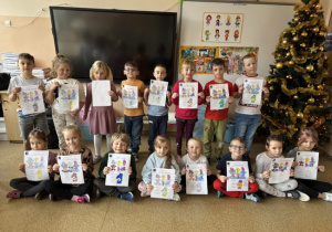 Dzieci pozują do zdjęcia z wykonanymi pracami