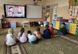 Dzieci oglądają bajkę Flinstonowie