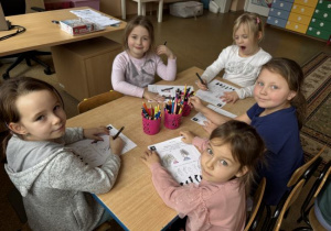 Dzieci wykonują karty pracy dotyczące oglądanej bajki