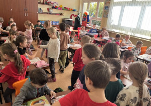 Dzieci wręczaja Usmiechnięte buźki uczniom klasy I