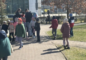 Dzieci wręczaja Usmiechnięte buźki przechodnim
