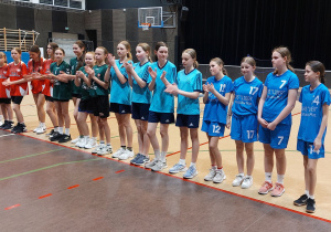 Grupa uczennic w sportowych strojch podczas dekoracji medlami.