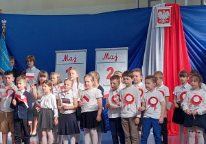 Duża grupa uczniów klasy 1a podczas śpiewu piosenki.