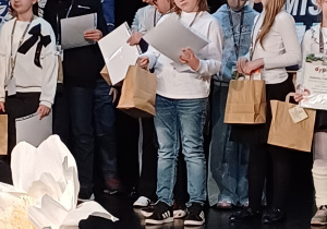 Grupa uczniów z dyplomami i nagrodami, wśród nich Mieszko.