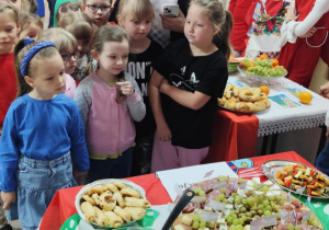 Dzieci zwiedzają przygotowane przez starszych uczniów stanowiska z wylosowanymi państawami.