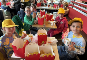 Dzieci jedzą posiłek w McDonalds