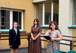Panie dyrektor i uczennicą witają uczniów, nauczycieli rodziców podczas pierwszego apelu.