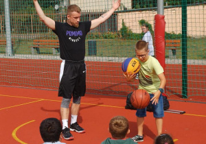 Uczeń naszej szkoły podczas dryblingu piłkami do koszykówki.
