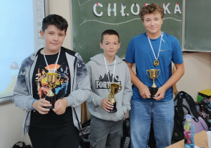 Trzech chłopców z 6a z pucharami w dłoniach.