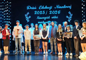 Duża grupa uczniów wraz z opiekunami podczas wręczania pamiątkowych pucharów za współzawodnictwo sportowe.