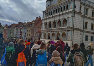 Uczestnicy wycieczki do Poznania w oczekiwaniu na sygnał pełnej godziny na rynku w Poznaniu.