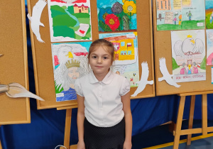 Jagoda Mazurek stoi przy swojej nagrodzonej pracy w konkursie plastycznym.