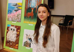 Nadia Fajfer stoi przy swojej nagrodzonej pracy plastycznej.