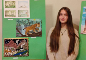 Oliwia przy swojej plastycznej pracy Eko-pocztówka.