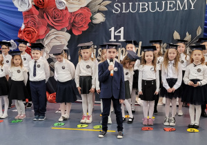 Cała klasa pierwsza ślubuje, powtarzając słowa roty przysięgi .